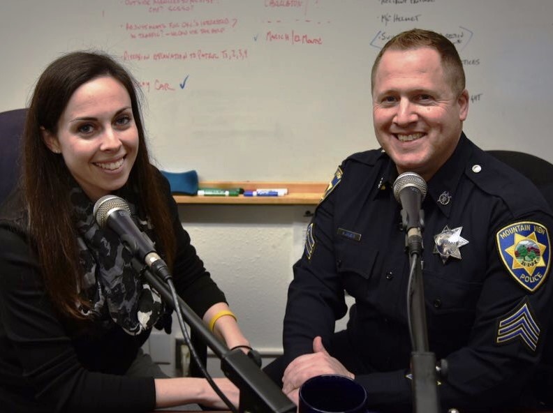 Police officers smiling behind microphones