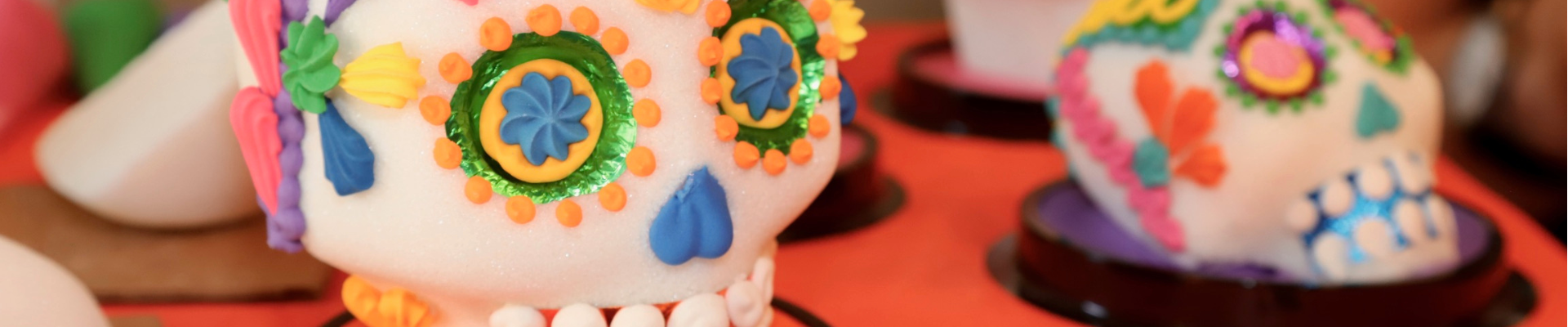 Sugar skull candies on an orange table at Día de Muertos 2023